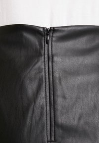 Zwarte leren rok met een gladde textuur, hoge taille ontwerp en een centrale ritssluiting aan de achterkant.