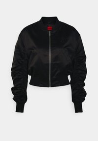 Zwarte satijnen bomberjack met een ritsluiting, ribgebreide mouwen en geraffineerde mouwen. Subtiele reliëflogo op de borst. Cropped ontwerp.