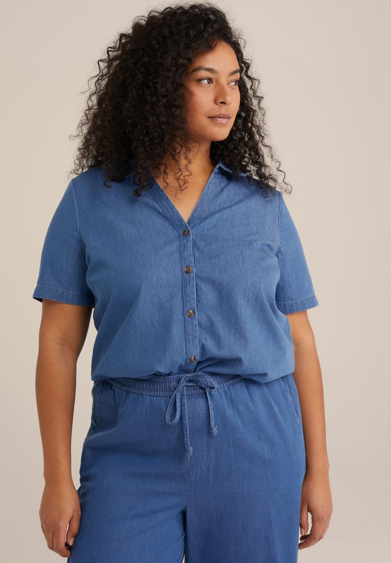 Chemise en denim bleu clair à manches courtes, avec un col, des boutons et une coupe décontractée, associée à un pantalon à taille élastique assorti.
