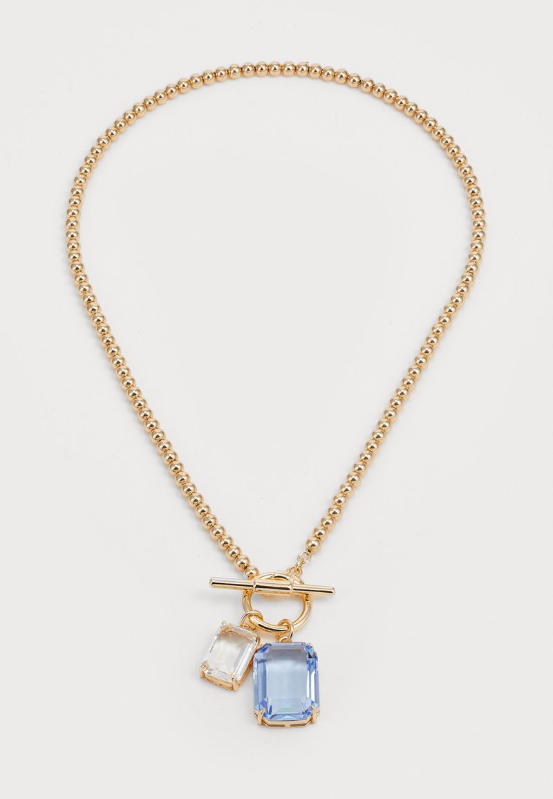 Colar de contas em tom de ouro com fecho tipo toggle, apresentando dois pendentes retangulares — um em cristal claro e outro em gema azul clara.