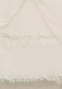 Gennemsigtig cremefarvet stof med en blød tekstur, der har uskarpe kanter og frynset pynt for en delikat finish. Simpelt og let design.