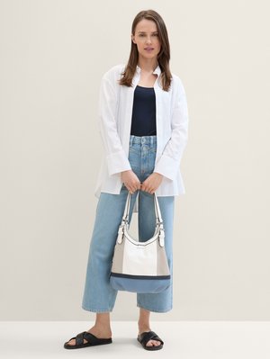 Witte button-up shirt, marineblauwe tanktop, lichtblauwe-wide-leg jeans, zwarte slidesandalen en een kleurblokhandtas in wit, grijs en blauw.
