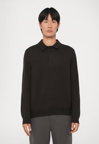 Suéter de punto acanalado en marrón oscuro con cuello tipo polo, tres botones y mangas largas. Tejido de punto texturizado y detalle de dobladillo ajustado.