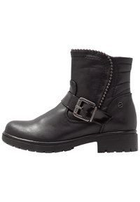 Bottine en cuir noir avec fermeture éclair sur le côté, clous décoratifs le long du col et un talon bloc robuste. Accent de boucle sur la sangle.