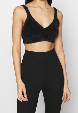 Schwarzes, kurz geschnittenes Bralette aus flauschigem Material mit tiefem V-Ausschnitt, breiten Trägern und einem strukturierten Design mit Spiral-Muster.