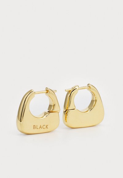 Brincos em forma de argola de tom dourado com um design escultural e geométrico. Apresentam um acabamento texturizado e a gravação "BLACK" de um lado.