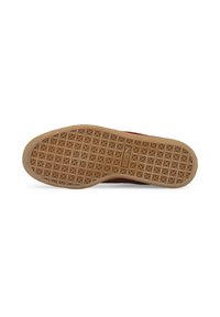 Zapatilla roja con una suela de goma texturizada que presenta un patrón de diamantes para mayor agarre. La suela exterior tiene un color goma y una silueta plana.