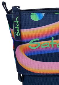 Dunkelblaues Stofftäschchen mit lebendigen, bunten runden Mustern, mit einem Reißverschluss und dem grünen, eingeprägten "Satch"-Logo an der Seite.