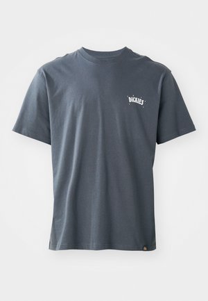 Dunkelgraues Baumwoll-T-Shirt mit kurzen Ärmeln und rundem Halsausschnitt. Mit einem kleinen weißen Logo auf der Brust und einem Etikett am unteren Saum.