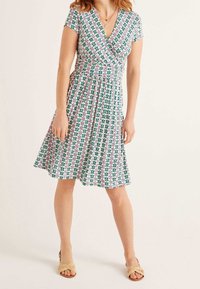 Wikkeljurk met korte mouwen, bloemenpatroon in groen, roze en wit, lichtgewicht stof, uitlopende rok en een comfortabele pasvorm.