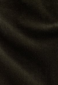 Tissu en velours côtelé vert foncé avec des côtes verticales, présentant une texture lisse et un éclat subtil, adapté pour le rembourrage ou l'habillement.