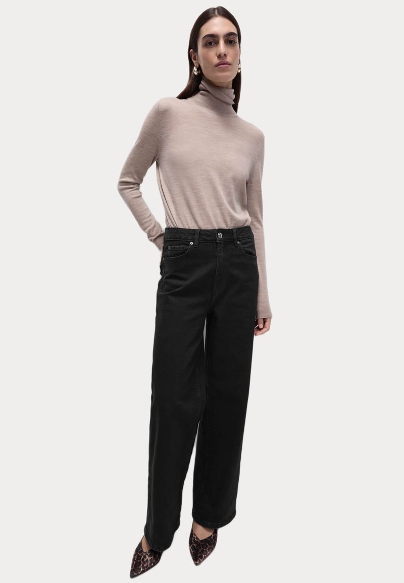 Beige rolák, černé široké kalhoty s předními kapsami a špičaté leopardí lodičky. Jednoduchý, těsně přiléhající design, formální textura.