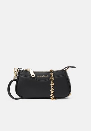Sac en cuir noir avec une finition texturée, quincaillerie dorée, fermeture éclair supérieure et un accent en chaîne comportant des lettres. Design compact et structuré.