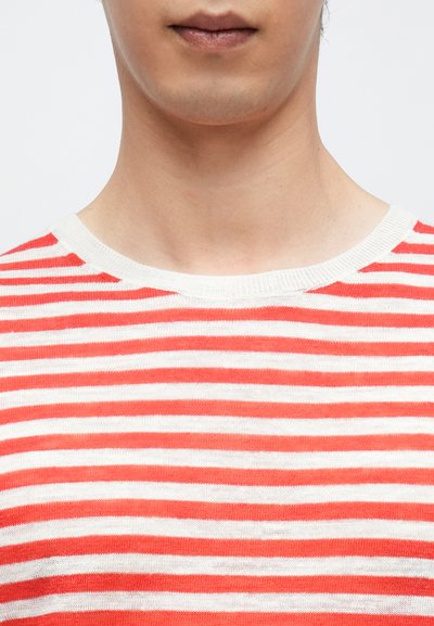 Πουλόβερ με κόκκινες και λευκές ρίγες, στρογγυλή λαιμόκοψη, κατασκευασμένο από ελαφρύ ύφασμα, με λεία υφή και ομοιόμορφες ρίγες.