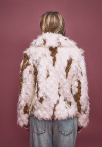 Giacca in pelliccia sintetica con base bianca e strisce marroni, caratterizzata da un colletto, maniche lunghe e un aspetto testurizzato e soffice.