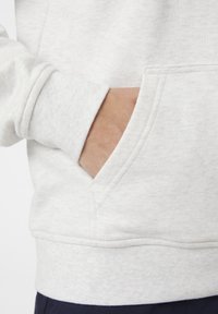 Sudadera gris claro con un bolsillo frontal, puños y dobladillo acanalados. El material presenta un acabado suave y texturizado.