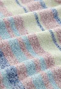 Tissu à texture douce avec des rayures pastel en bleu, rose, vert et marine, présenté en plis délicats.
