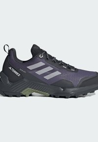 Mörklila vandringsskor i syntetmaterial, med grå ränder, en texturerad svart överdrag och en robust sula för grepp.