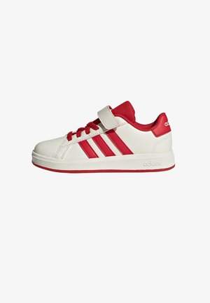Sneaker Adidas bianco e rosso con tre strisce rosse, lacci rossi, strap in velcro e rivestimento interno rosso, visto di lato.