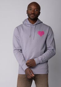 Grijze hoodie met een grote roze hartontwerp op de linkerkant van de borst. Beschikt over trekkoorden, een voorkant zak en ribbelboorden. Zachte stofstructuur.