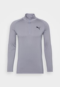 Jasnoszara, długorękawowa odzież sportowa z zamkiem na ćwierć i czarnym logo Puma po lewej stronie klatki piersiowej na białym tle.