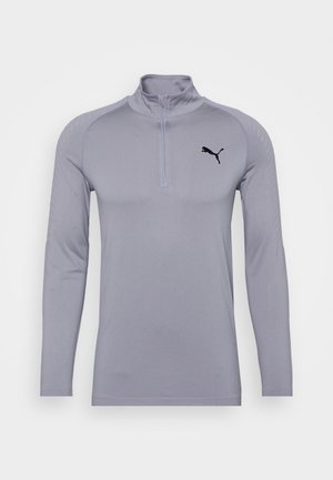 Světle šedé sportovní tričko s dlouhým rukávem, čtvrtinovým zipem a černým logem Puma na levé hrudi na bílém pozadí.