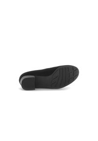 Black slip-on shoe with a smooth upper, rounded toe, and a rubber sole featuring a textured grip pattern. Low, slightly broad heel.
