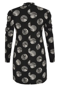 Robe noire à manches longues, présentant un motif de formes circulaires blanches et de rayures. Tissu texturé avec un détail froncé à l'épaule.