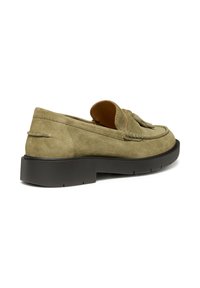 Scarpa mocassino verde in suede con suola in gomma nera, caratterizzata da un tassello decorativo e da dettagli di cucitura lungo il bordo superiore.