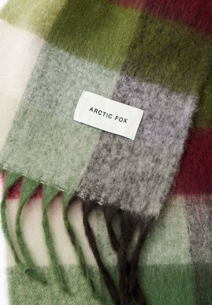 Écharpe à carreaux en laine présentant des carrés verts, gris, rouges et blancs ; finie avec des bords fringés et une étiquette blanche portant la mention "ARCTIC FOX."