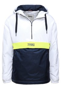 Pulloverjacka med vit ovandel, marinblå nederdel och neon gul horisontell rand. Har en huva, halvdragkedja fram och justerbara snoddar.