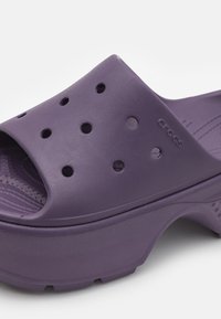 Paarse Crocs sandalen met open teen, gemaakt van lichtgewicht materiaal, met ventilatiegaten, een geprofileerde binnenzool en een platformzool.