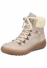 Botte chelsea beige à lacets avec un col en fausse fourrure texturée, œillets en métal et semelle en caoutchouc avec motif antidérapant.