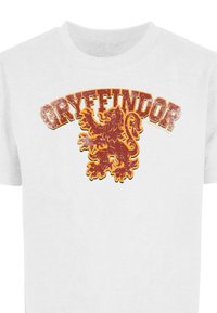 Tricou alb cu un logo Gryffindor deteriorat, îndrăzneț, în roșu și auriu și un grafic cu leul pe față.
