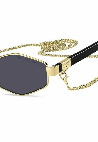 Gafas de sol con forma hexagonal, marco de metal dorado, lentes ahumados grises, varillas negras y una cadena dorada desmontable unida.