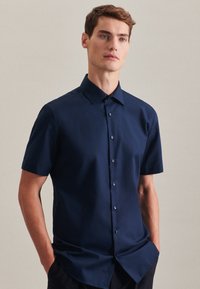 Camicia da uomo a maniche corte in tessuto blu scuro, con colletto a punta e chiusura con bottoni. Taglio aderente con una texture liscia.