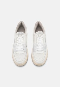 White leather sneakers with perforated detailing, textured suede accents, and a cream-colored rubber sole. Features white laces and branding.