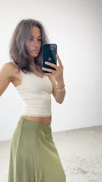 Kreemika värvi tank top pitsäärisega, koos voolava oliivroheline seelikuga. Taustal on neutraalne keskkond.