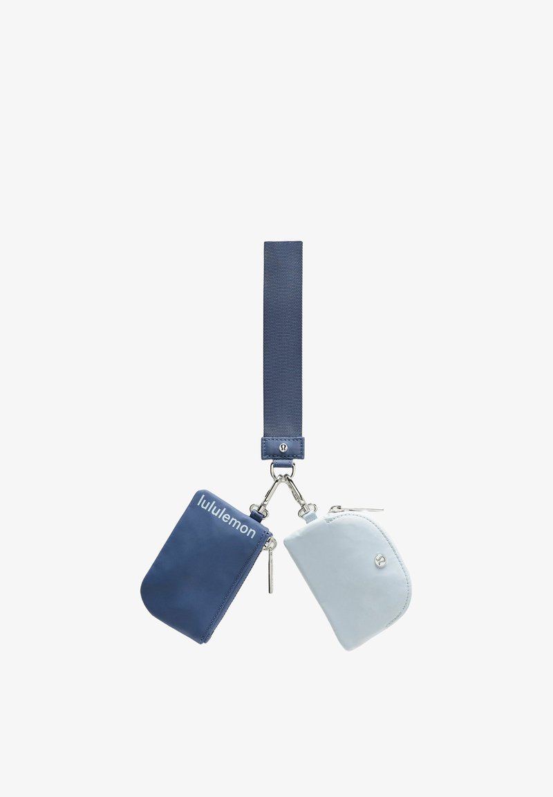 Blaue und graue Taschen mit Reißverschluss, die an einem marineblauen Riemen befestigt sind, mit glatter Textur und silberfarbenen Beschlägen, eines der Täschchen mit Logodetail.