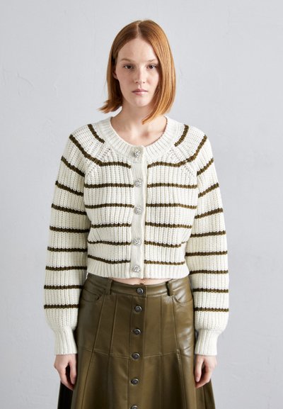 Cardigan blanc tricoté avec des rayures marron, doté d'un col et de poignets côtelés, et de cinq boutons décoratifs sur le devant.
