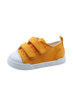 Zapatilla de lona amarilla con dos correas de velcro, puntera de goma blanca y suela blanca texturizada. Marca mínima en el costado.