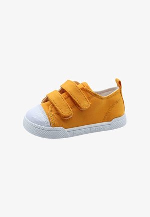 Zapatilla de lona amarilla con dos correas de velcro, puntera de goma blanca y suela blanca texturizada. Marca mínima en el costado.