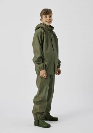 Ensemble de pluie imperméable vert olive composé d'une veste à capuchon avec des poignets élastiques et un pantalon assorti, accompagné de bottes en caoutchouc vertes.