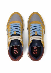 Coppia di scarpe da ginnastica multicolore con lacci blu e beige, dettagli in camoscio senape, rete grigia e accenti rossi con motivo sul tallone, vista dall'alto.