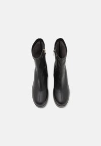 Schwarze Leder-Stiefeletten mit glatter Oberfläche, seitlichen Reißverschlüssen und runder Zehenform, entworfen für eine enge Passform und Langlebigkeit.