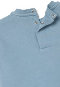 Pullover di cotone azzurro chiaro con colletto alto, dotato di due bottoni a pressione in metallo e texture a costine sul colletto e sui polsini.