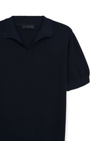 Polo shirt blu navy in tessuto a costine, con colletto ripiegato, maniche corte e taglio dritto, caratterizzato da un sottile etichetta del marchio all'altezza del collo.