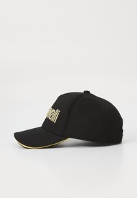 Black baseball cap with gold embroidered lettering and a gold accent on the visor. Made of fabric, featuring a curved brim and adjustable strap.