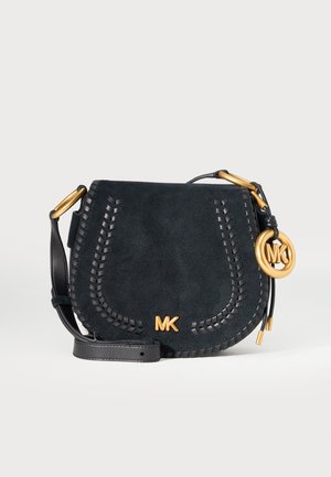 Sac bandoulière en daim noir avec bordure tressée, sangle en cuir ajustable, logo MK doré et breloque sur fond blanc.