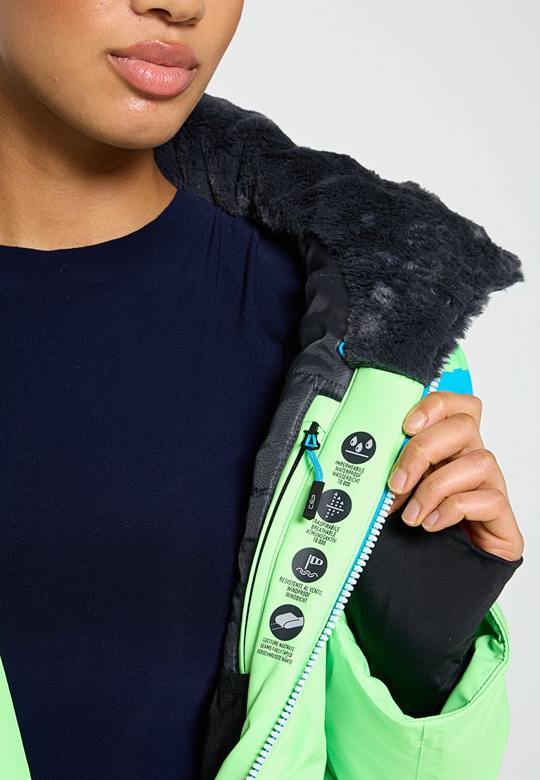Person, der eine offene grüne Jacke mit schwarzem Fleece-Futter hält, in der die Symbole für wasserdicht, atmungsaktiv, winddicht und geklebte Nähte zu sehen sind.